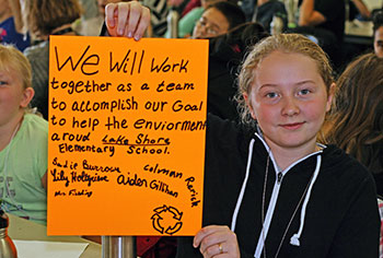 student holding green pledge sign